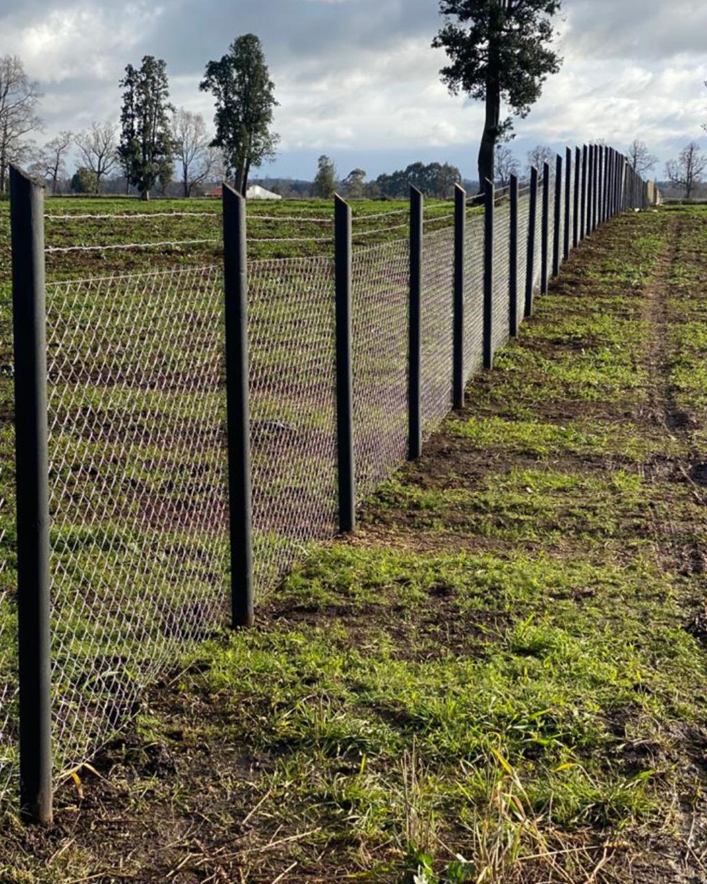 Cerco perimetral con polines metálicos en campo, VI Región